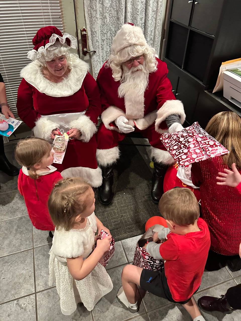Santa handing gifts to delighted children at a North Shore Christmas party